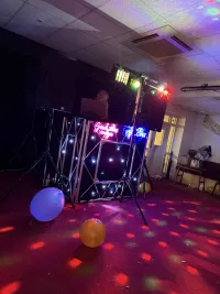 A photo of Jon standing behind the decks at an event
