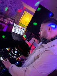 A close up photo of Shaun using the DJ Decks at an event