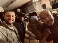 A photo of Shaun and Jon posing with their manager Angie Brown